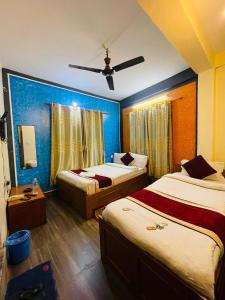 um quarto de hotel com 2 camas e uma ventoinha de tecto em Hotel old durbar em Pokhara