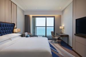 a hotel room with a bed and a desk and a television at Four Points by Sheraton Danang in Da Nang