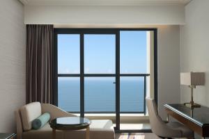 a living room with a desk and a large window at Four Points by Sheraton Danang in Da Nang