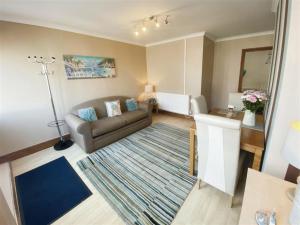 a living room with a couch and a rug at The Gateway a lovely Spacious Seaside Property close to the beaches , centrally located in Porthcawl in Newton