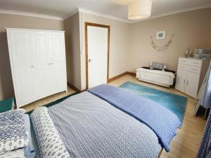 um quarto com uma cama com um edredão azul em The Gateway a lovely Spacious Seaside Property close to the beaches , centrally located in Porthcawl em Newton