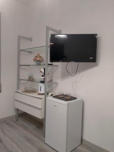 a flat screen tv hanging on a white wall at Setta Apartment in Lido di Ostia