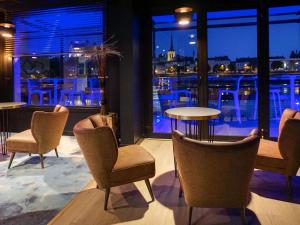 a restaurant with chairs and a table and a window at Mercure Bords de Loire Saumur in Saumur