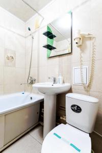 a bathroom with a toilet and a sink and a bath tub at Мандарин in Petropavlovsk