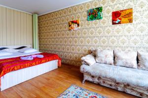 1 dormitorio con 1 cama y 1 sofá en Мандарин, en Petropavlovsk