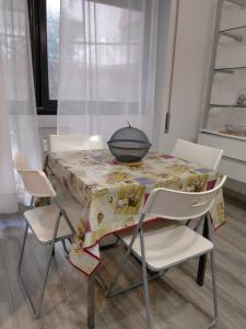 a table with chairs and a bowl on top of it at Setta Apartment in Lido di Ostia