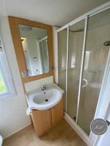 ein Badezimmer mit Waschbecken und Dusche in der Unterkunft Palm Grove 28 - Golden Palm - Central heating, pet friendly, WiFi, bed linen - Meadow Lakes Caravan & Lodge Hire in Chapel Saint Leonards