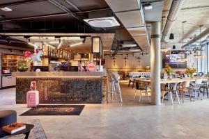 a restaurant with tables and chairs and a bar at Moxy Karlsruhe in Karlsruhe