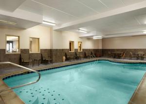 una piscina en una habitación de hotel con sillas y mesas en Hampton Inn Troy, en Troy
