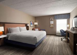 a hotel room with a bed and a desk at Hampton Inn Troy in Troy