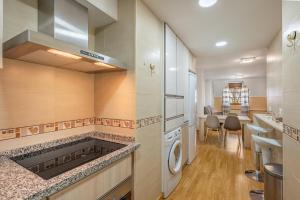 モナチルにあるApartamento ladera de Sierra Nevadaのキッチン(コンロ、洗濯機、乾燥機付)