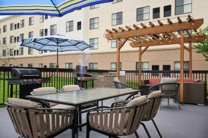 a patio with a table and chairs and a grill at Homewood Suites by Hilton Anchorage in Anchorage