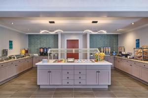 Homewood Suites by Hilton Anchorage في أنكوراج: مطبخ كبير مع دواليب بيضاء وجزيرة كبيرة