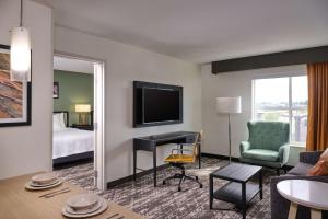 una sala de estar con una habitación con cama y TV en Homewood Suites by Hilton Anchorage en Anchorage