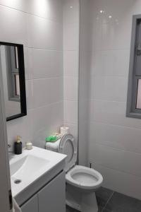 Baño blanco con aseo y lavamanos en emily apartment, 