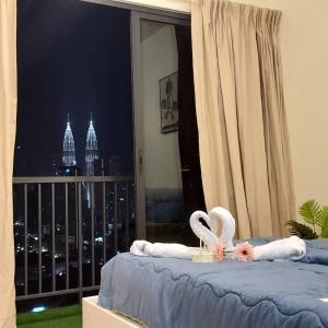 a bedroom with a bed with a view of the city at KLCC View with balcony Chambers Suites KL in Kuala Lumpur