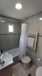 Un baño con bañera, lavabo e inodoro. en MERMOZ, en El Chaltén
