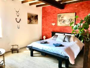 a bedroom with a bed and a red wall at Escapade dans la campagne toulousaine in Beaumont-sur-Lèze