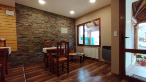 a dining room with a brick wall at MERMOZ in El Chalten