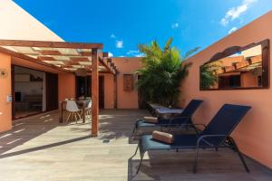 eine Terrasse mit Stühlen und einem Tisch in einem Haus in der Unterkunft Villa Roby Corralejo in La Oliva