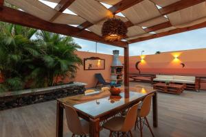 Villa Roby Corralejo في لا أوليفا: غرفة معيشة مع طاولة وكراسي خشبية