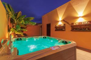 Villa Roby Corralejo في لا أوليفا: يوجد حوض جاكوزي في غرفة مع مقبلات.