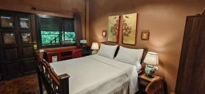 a bedroom with a large white bed and a window at Hoh Guesthouse in Chiang Mai