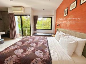 ナイヤンビーチにあるIdeo Phuket Hotel - SHA Extra Plusのベッドルーム1室(オレンジ色の壁の大型ベッド1台付)