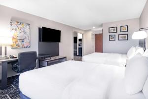a hotel room with two beds and a desk at La Quinta by Wyndham Evansville in Evansville
