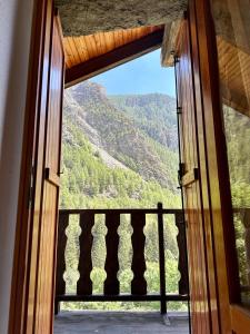 eine offene Tür zu einem Balkon mit Bergblick in der Unterkunft Cozy Chalet With Mountain Views in Ussin, Valtourneche, Parking in Chamois