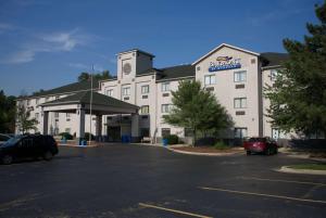 a large building with a parking lot in front of it at Baymont by Wyndham Portage in Portage