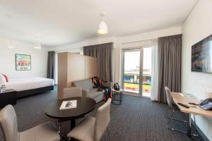 a hotel room with a bed and a table and chairs at Rydges Pit Lane in Tailem Bend