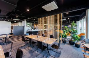 uma sala de jantar com mesas, cadeiras e plantas em Rydges Pit Lane em Tailem Bend