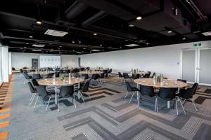 a large room with tables and chairs in it at Rydges Pit Lane in Tailem Bend