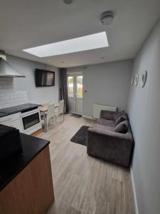 a living room with a couch and a kitchen at 1B Smart Apartments in Newark-on-Trent