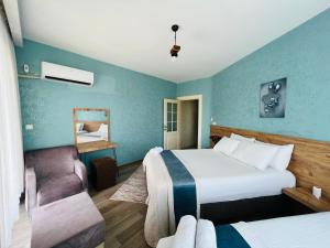 una camera d'albergo con due letti e una sedia di aria plus ev-otel a Çiftlikköy