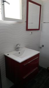 a bathroom with a sink and a mirror at arad rooms & apartments חדרי אירוח ערד in Arad