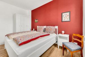 1 dormitorio con cama blanca y pared roja en Altstadt-Refugium Goslar en Goslar