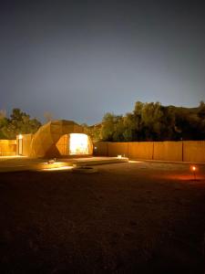 منتجع جلامبنغ - Glamping Resort في Al Fawwāz: خيمة مضاءة في موقف للسيارات في الليل