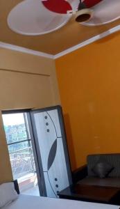 Cette chambre dispose d'un ventilateur de plafond et d'une chaise. dans l'établissement OYO Hotel Krishna Garden, à Nawāda