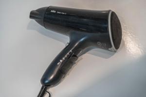 a black hair dryer sitting on a white surface at Ferienwohnung Panorama in Neusatzeck