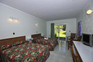 a hotel room with a bed and a flat screen tv at Kosrae Nautilus Resort in Yepan