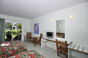 Habitación con 2 camas y escritorio con TV. en Kosrae Nautilus Resort, en Yepan