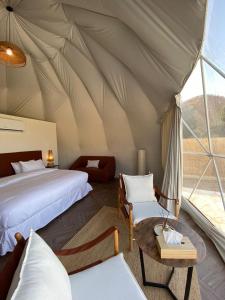 una camera da letto in tenda con 2 letti e un tavolo di منتجع جلامبنغ - Glamping Resort a Al Fawwāz