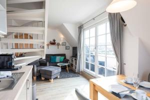 a kitchen and living room with a large window at LH Dwarslöper, App 3 in Wenningstedt