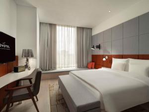 a bedroom with a large white bed and a desk at Novotel Shanghai Hongqiao Exhibition in Shanghai