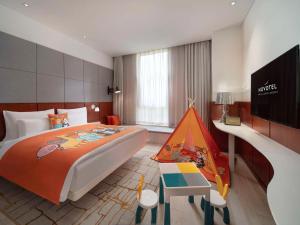 ein Schlafzimmer mit einem großen Bett und einem Spielzeugzelt in der Unterkunft Novotel Shanghai Hongqiao Exhibition in Shanghai