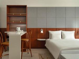 a hotel room with a bed and a bar at Novotel Shanghai Hongqiao Exhibition in Shanghai