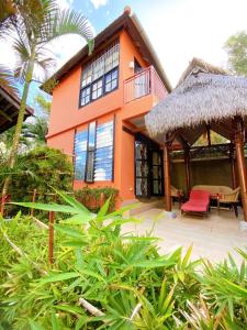 an orange house with a thatch roof at Villa Kinandari Bukit Jimbaran in Jimbaran