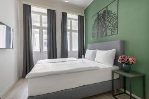 1 dormitorio con 1 cama grande y paredes verdes en Kinsky Garden Apartments and Suites, en Praga